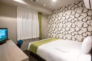 a hotel room with a bed and a television at Kuretake-Inn Hamamatsueki Minamiguchi Premium in Hamamatsu