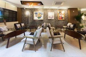 a restaurant with chairs and tables and a brick wall at Vistacay Hotel Worldcup in Seogwipo