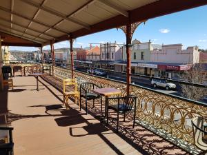 a balcony with a table and chairs on a train station at Great Central Hotel in Glen Innes