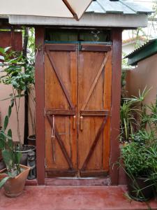 una vecchia porta in legno in un giardino con piante di Pimthong Place a Bangkok