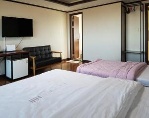 sypialnia z łóżkiem, kanapą i telewizorem w obiekcie Goodstay Motel Hill w mieście Gangneung