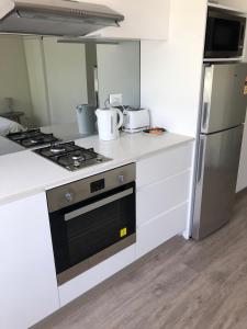 a kitchen with a stove and a refrigerator at Bondi Beach Studio King Suite + Balcony in Sydney