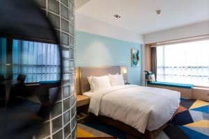 a hotel room with a bed and a window at Holiday Inn Express Chengdu Xindu, an IHG Hotel in Chengdu