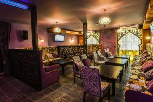 Un restaurante con mesas y sillas en una sala. en Arirang Hotel, en Khabarovsk