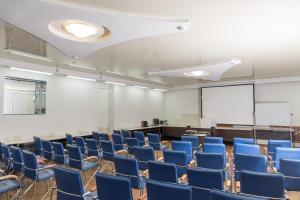 una habitación vacía con sillas azules y una pantalla blanca en Arirang Hotel, en Khabarovsk