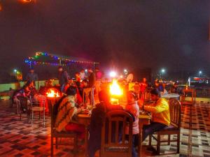um grupo de pessoas sentadas às mesas à noite em Ranthambore Tiger Home em Sawai Madhopur