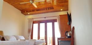 a bedroom with two beds and a wooden ceiling at Free Beach Resort in Phú Quốc