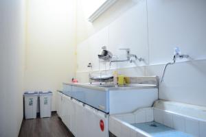 a white bathroom with a sink and a sink at Nishioji KADO 西大路 角 わんちゃんと泊まれるお宿 in Kyoto +47 photos