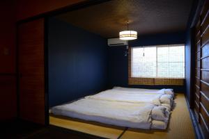 a bed in a blue room with a window at Nishioji KADO 西大路 角 わんちゃんと泊まれるお宿 in Kyoto
