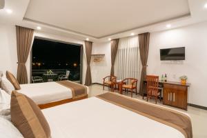 a hotel room with two beds and a table at Horizon 2 villa in Hoi An