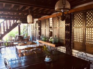 a restaurant with wooden walls and tables and chairs at Mount Pinatubo Base Camp at CASA HERMOGINA in Santa Juliana