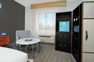 Habitación de hotel con cama, mesa y TV. en Hotel Ylem en Houston