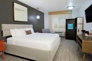 a bedroom with a large white bed and a desk at Hotel Ylem in Houston