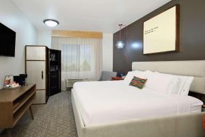 Habitación de hotel con cama blanca grande y escritorio. en Hotel Ylem en Houston