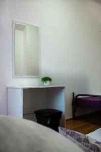 a bedroom with a mirror and a table with a chair at Simple Seasons Rooms - Самозаселение in Saint Petersburg