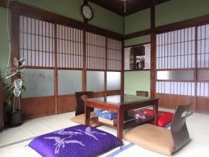 a room with a table and chairs and a clock at ゲストハウス杉田 古民家貸切の完全プライベート空間 杉田駅徒歩2分 セルフチェックイン in Yokohama