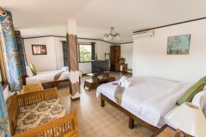 a living room with two beds and a television at Somwang Boutique Hotel in Chiang Mai