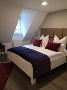 a bedroom with a large bed with red pillows at Trip Inn PostApart Aschaffenburg in Aschaffenburg