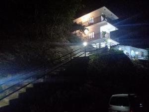 a house with lights on the side of it at night at Mountain Breeze Villa and Homestay in Idukki
