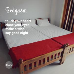 a bed with a red and white blanket on it at Mountain Breeze Villa and Homestay in Idukki