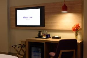 a room with a table with a tv on the wall at Mercure Selangor Selayang in Batu Caves