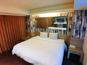 um quarto com uma grande cama branca e uma janela em Love Hotel em Taipei