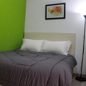 Bett in einem Zimmer mit grüner Wand in der Unterkunft Rumah99 in Jakarta