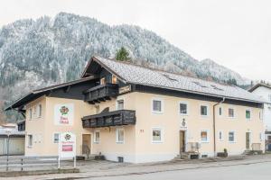 a large building with a mountain in the background at Pension Freiheit in Pfronten