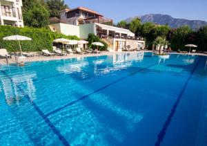 a large blue swimming pool with chairs and umbrellas at Hotel Greenland - All Inclusive in Oludeniz