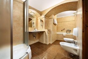 a bathroom with two sinks and a tub and a toilet at Hotel Konvice in Český Krumlov