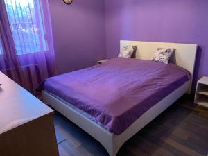Fantastic 3 bedroom Apartment في صوفيا: غرفة نوم مع سرير مع ملاءات أرجوانية ونافذة