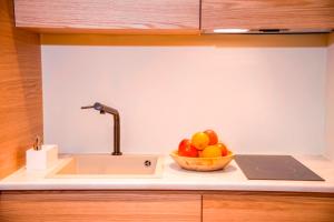 a bowl of fruit on a counter with a sink at Portou House in Chania