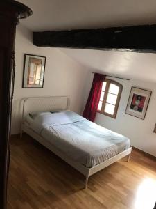 een slaapkamer met een bed en twee ramen. bij La Maison entre les arènes et la gare in Arles