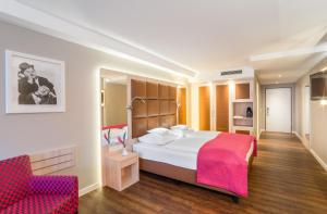 a hotel room with a bed and a chair at Hollywood Media Hotel am Kurfürstendamm in Berlin +37 photos