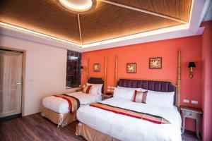 two beds in a room with orange walls at Dreamer Boutique Hotel in Nanwan