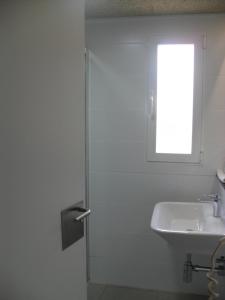 a white bathroom with a sink and a window at Hotel Lo Monte in Pilar de la Horadada