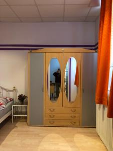 a bedroom with a dresser with two mirrors on it at Munich Apartment Harras (Souterrain) in Munich