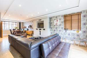 uma sala de estar com um sofá e uma mesa em Harlesden House em Romford