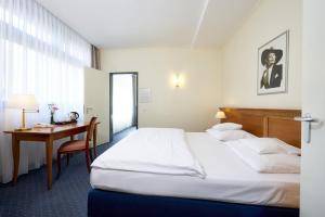 a hotel room with a bed and a desk at Hollywood Media Hotel am Kurfürstendamm in Berlin