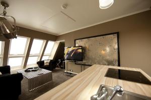 a room with a living room with a television at Boutique-Hotel GEORGES in Essen