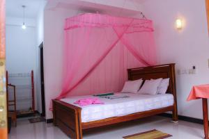 Un dormitorio con una cama con mosquitera rosa. en Lilac Garden Mirissa, en Weligama 14 fotos más