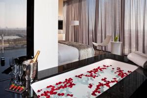 a hotel room with a bath tub filled with red roses at Melia Vienna in Vienna