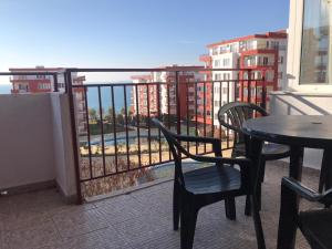 a balcony with a table and chairs on a balcony at Kalina Private Apartments in Marina View Fort Beach, Sveti Vlas in Sveti Vlas