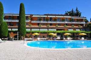 a hotel with a swimming pool in front of a building at Hotel Garden in Garda