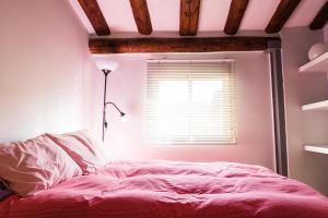 サラゴサにあるFANTASTICA BUHARDILLA PZ. PILARのベッドルーム1室(ピンクベッド1台、窓付)