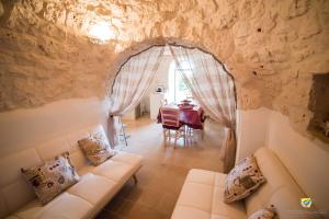 uma sala de estar com um sofá e uma mesa em La linea dell'orizzonte em Alberobello