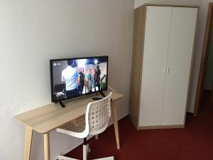 a television sitting on a desk in a room at Jimmy Gastronomie & Übernachtung in Altheim