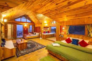 Cheog的住宿－Zostel Homes Cheog (Shimla)，小屋内带绿色沙发的客厅
