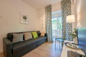 uma sala de estar com um sofá e uma janela em Paiva Cozy Home em Lisboa