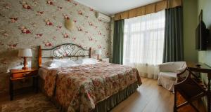 a bedroom with a bed and a dresser at Konyushenny Dvor Guest House in Ryazan